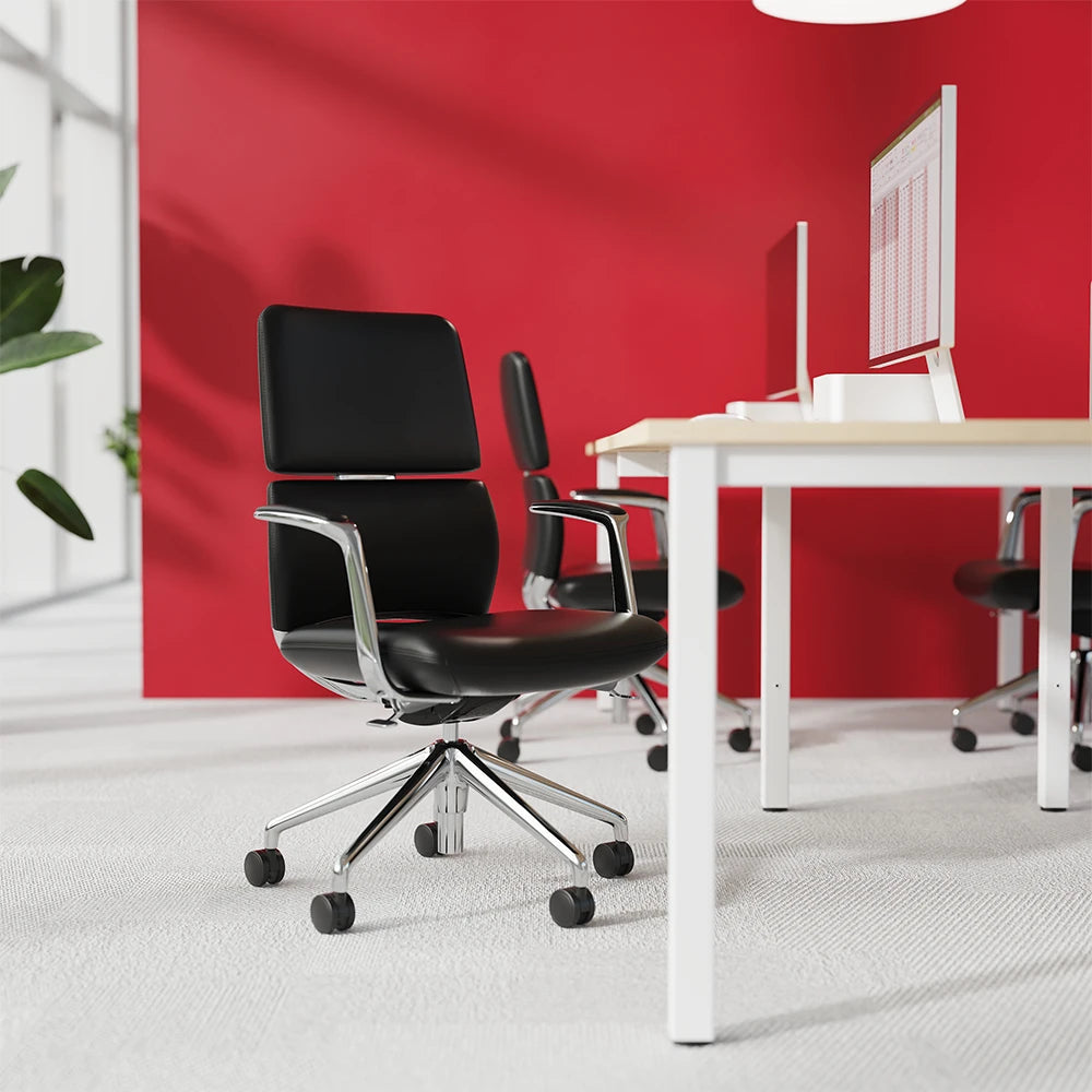 Office setting with chairs, desk and monitors with plants and red wall in the background