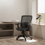 Black mesh chair in a room setting with desk and and a window in the background