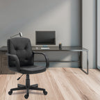 Modern office setup with a black office chair and desk against a gray wall.