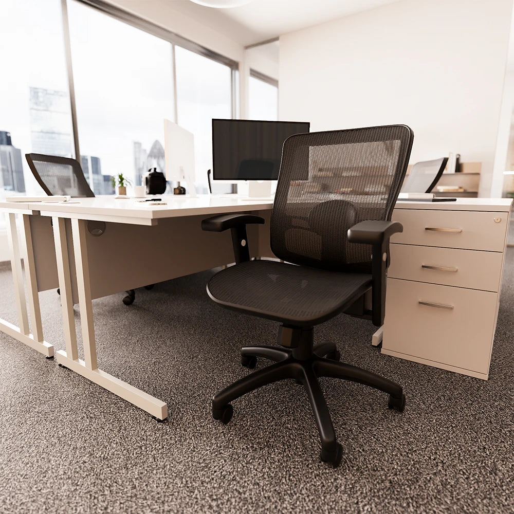Office workstation with mesh chair, desk, pedestal and monitor with windows in a background