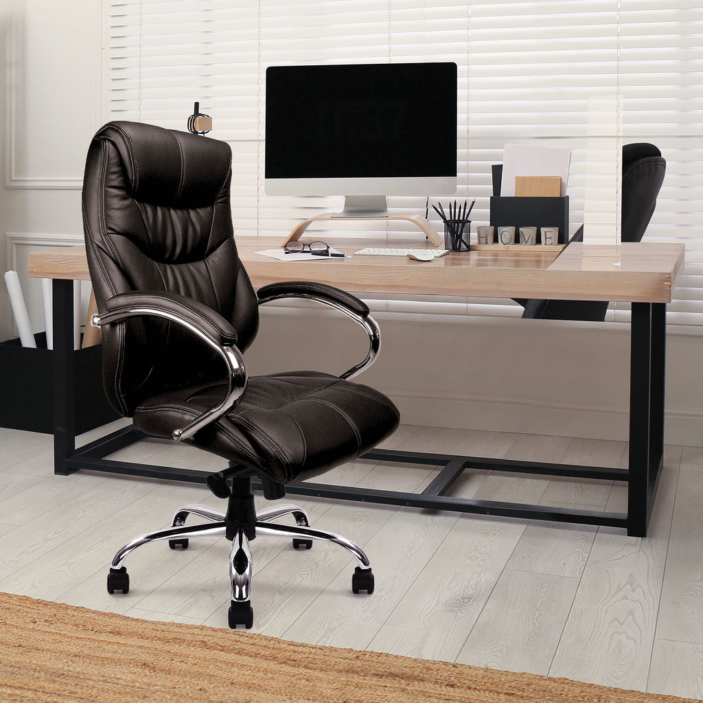 Black office chair in front of a wooden desk with a computer setup.