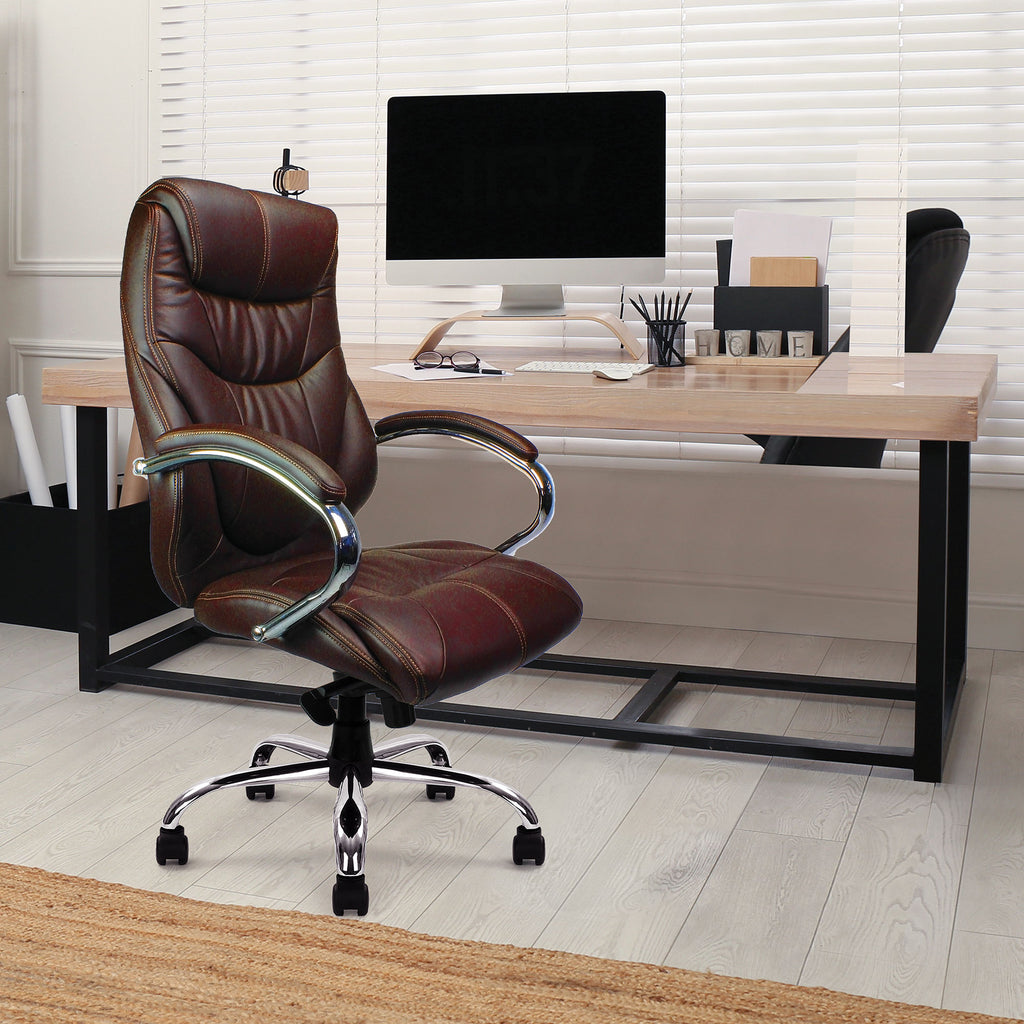 Brown leather office chair in front of a desk with a computer setup.