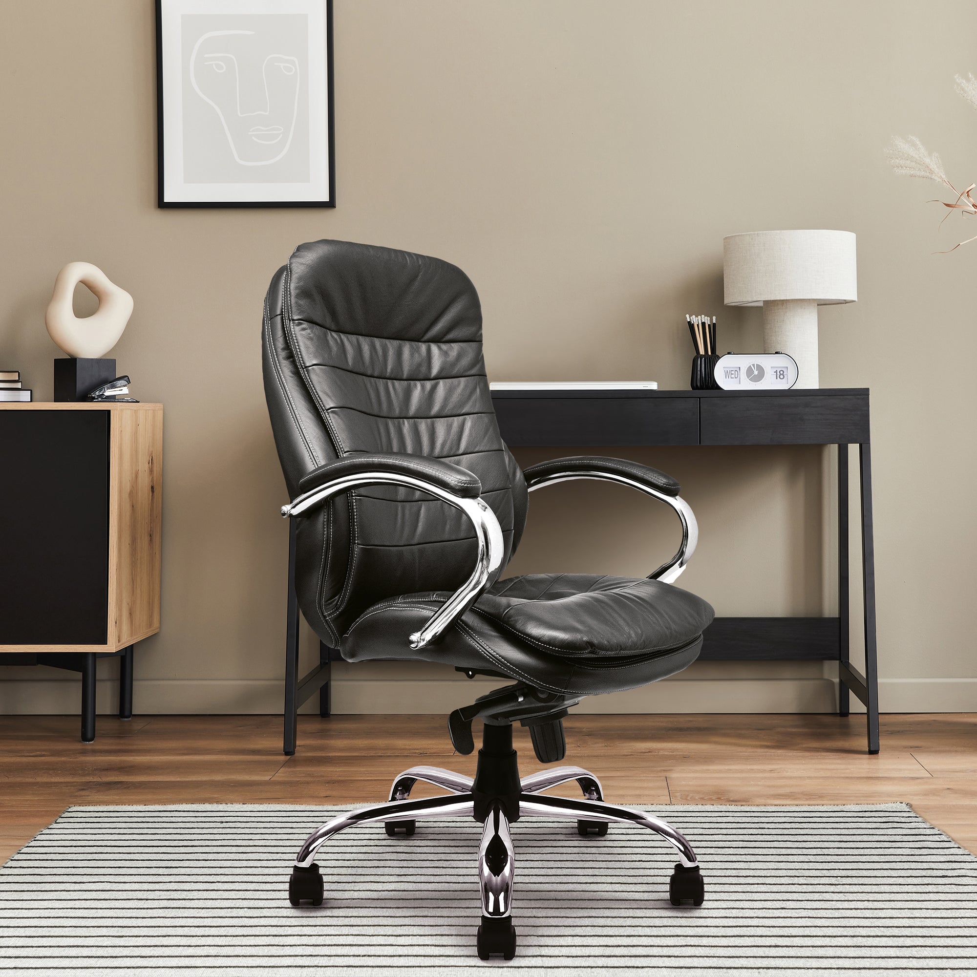 Black leather office chair in a modern office setting with a desk and decor.