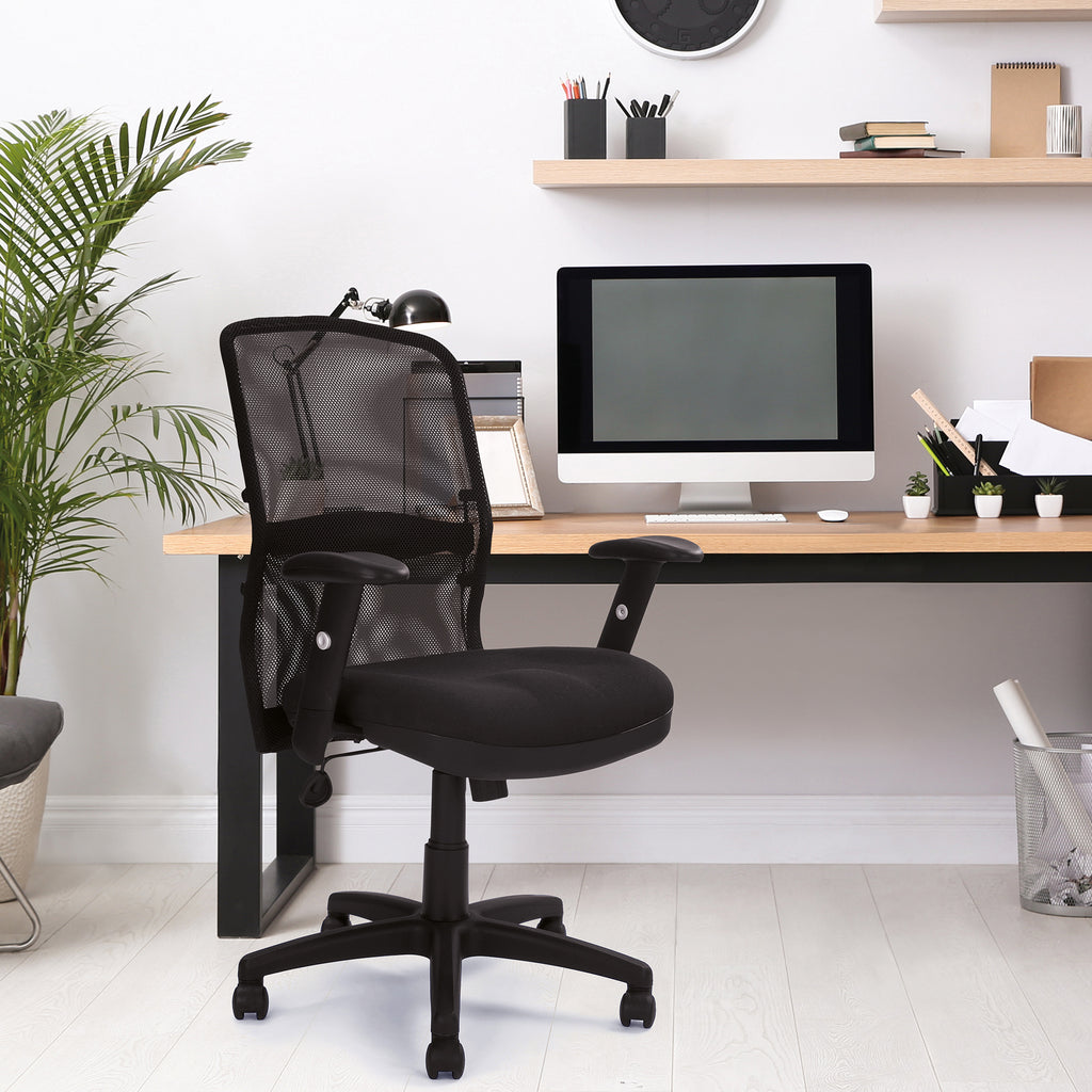 Black office chair in front of a wooden desk with a computer setup in a home office.