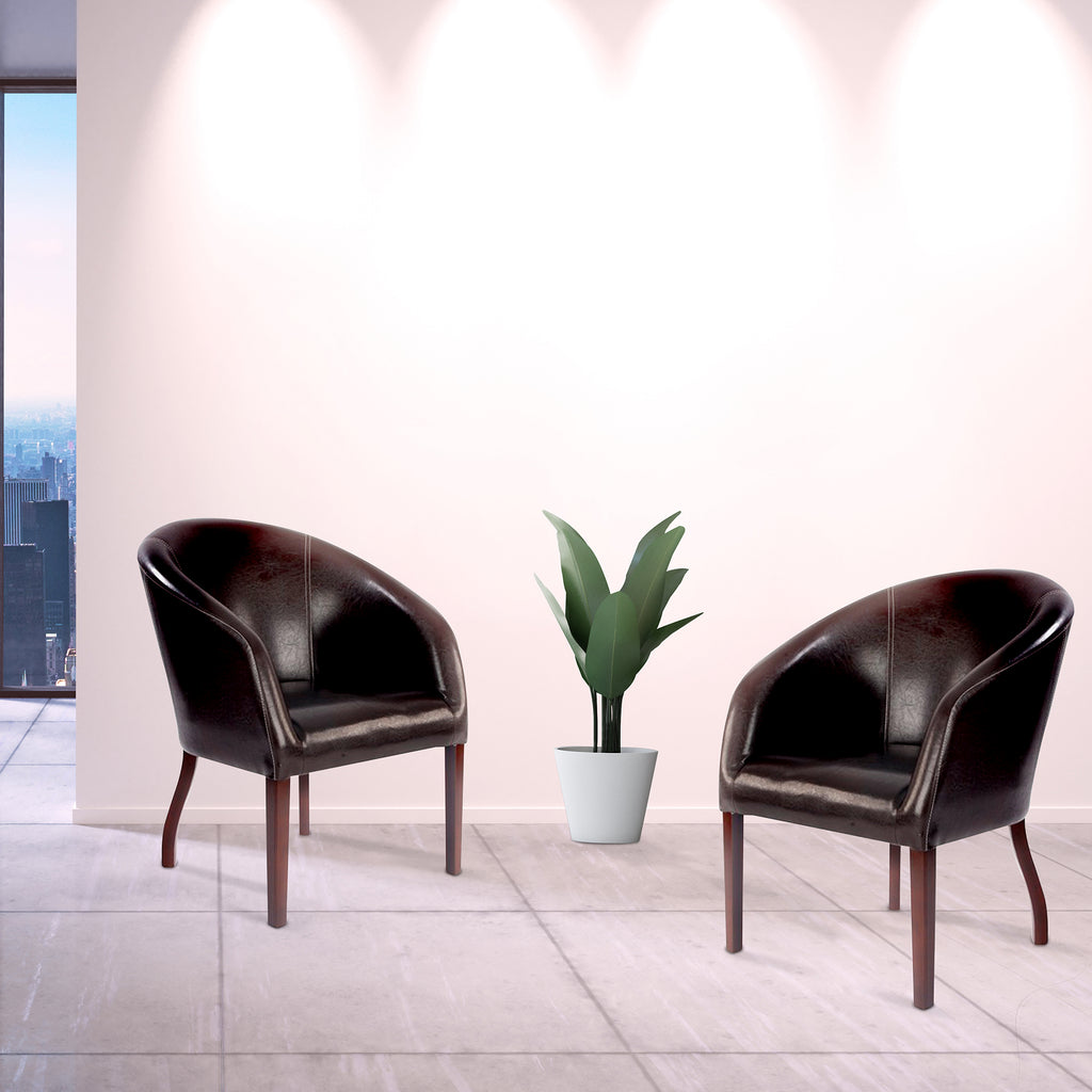 Two dark brown armchairs with a potted plant in an office setting.