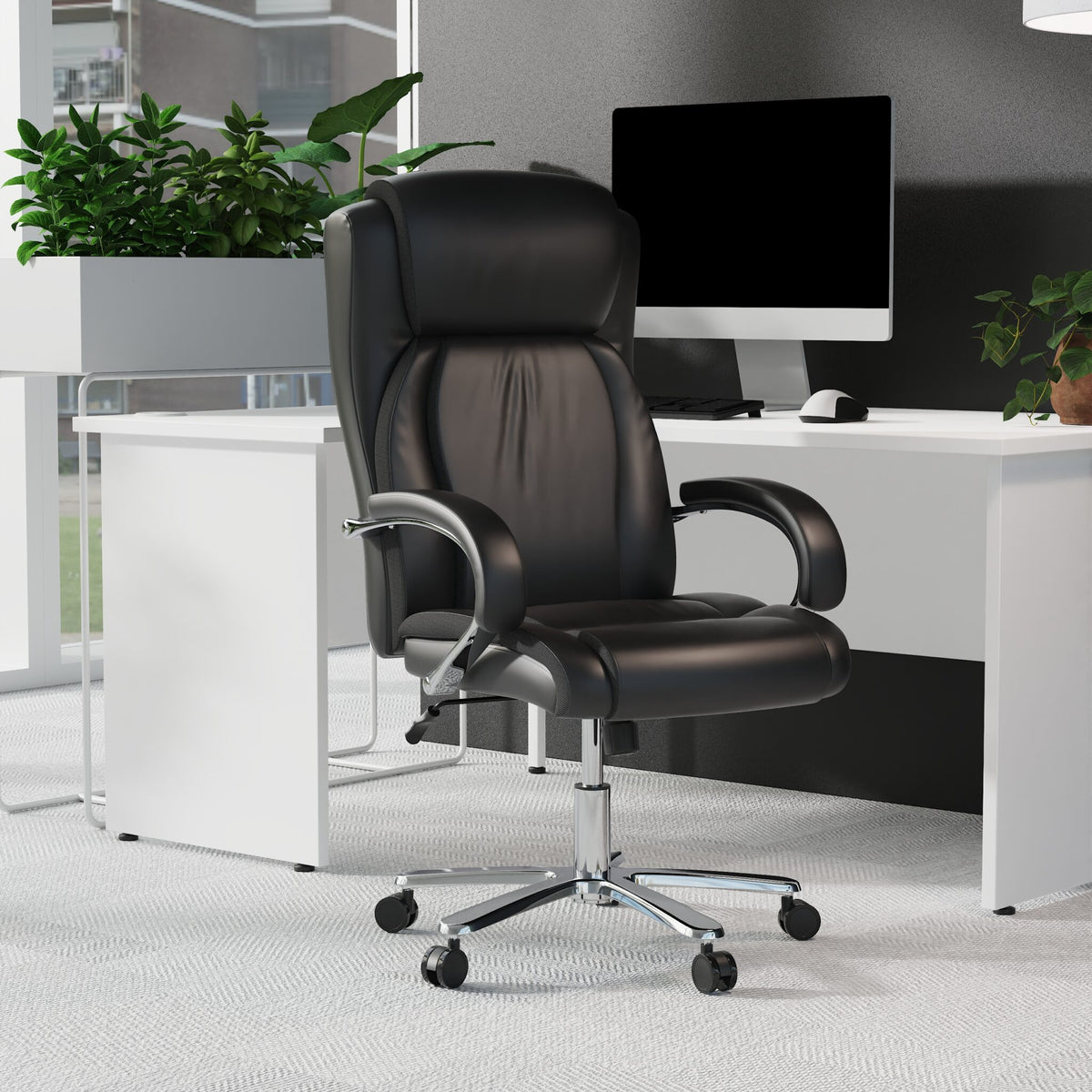 Black office chair in an office setting with a desk and computer monitor.