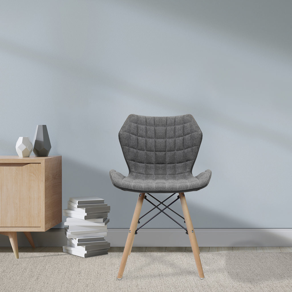 Grey upholstered chair with wooden legs in a room with a light grey wall and wooden side table.