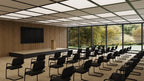 Modern conference room with rows of chairs and a large screen on a wooden wall.