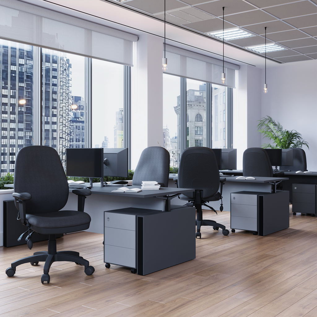 Modern office setup with desks, chairs, and large windows overlooking a cityscape.