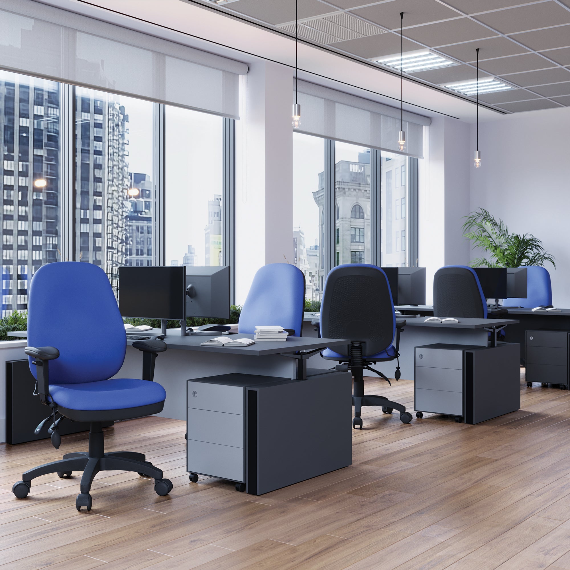 Modern office setup with blue chairs, desks, and computer monitors in a bright room with large windows.