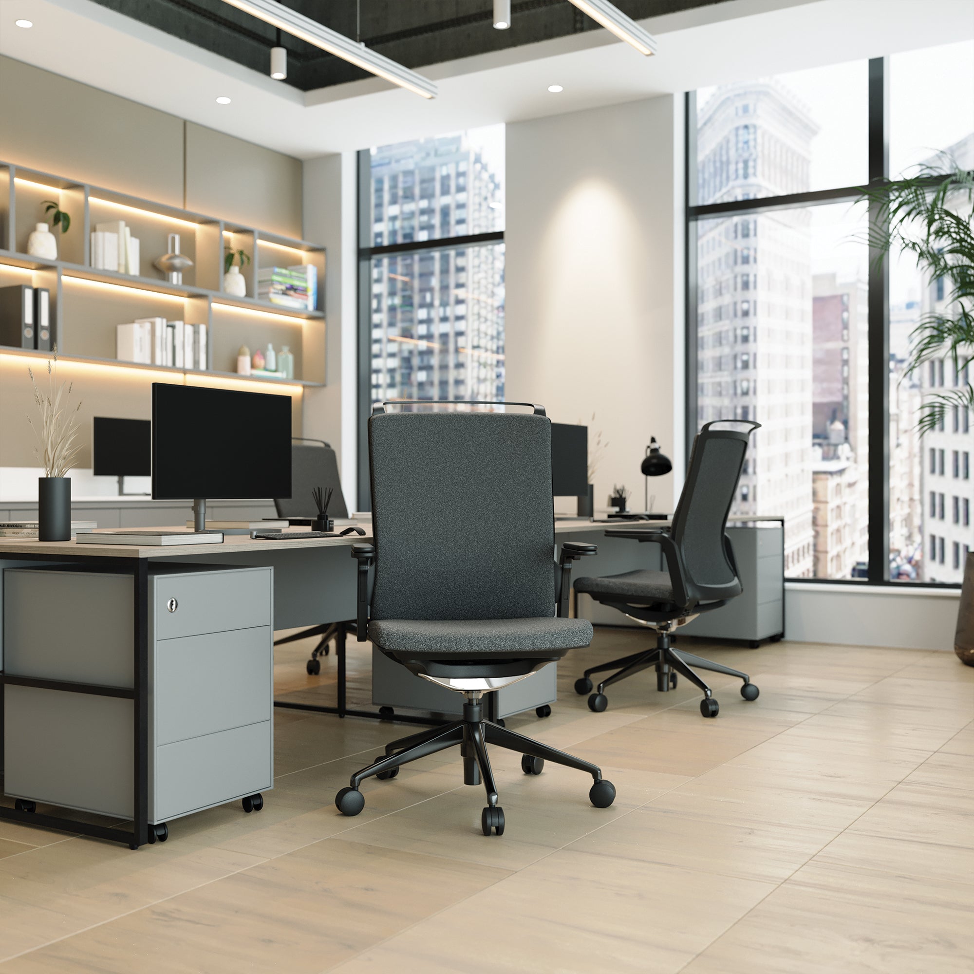 Modern office space with desks, chairs, and large windows overlooking a cityscape.