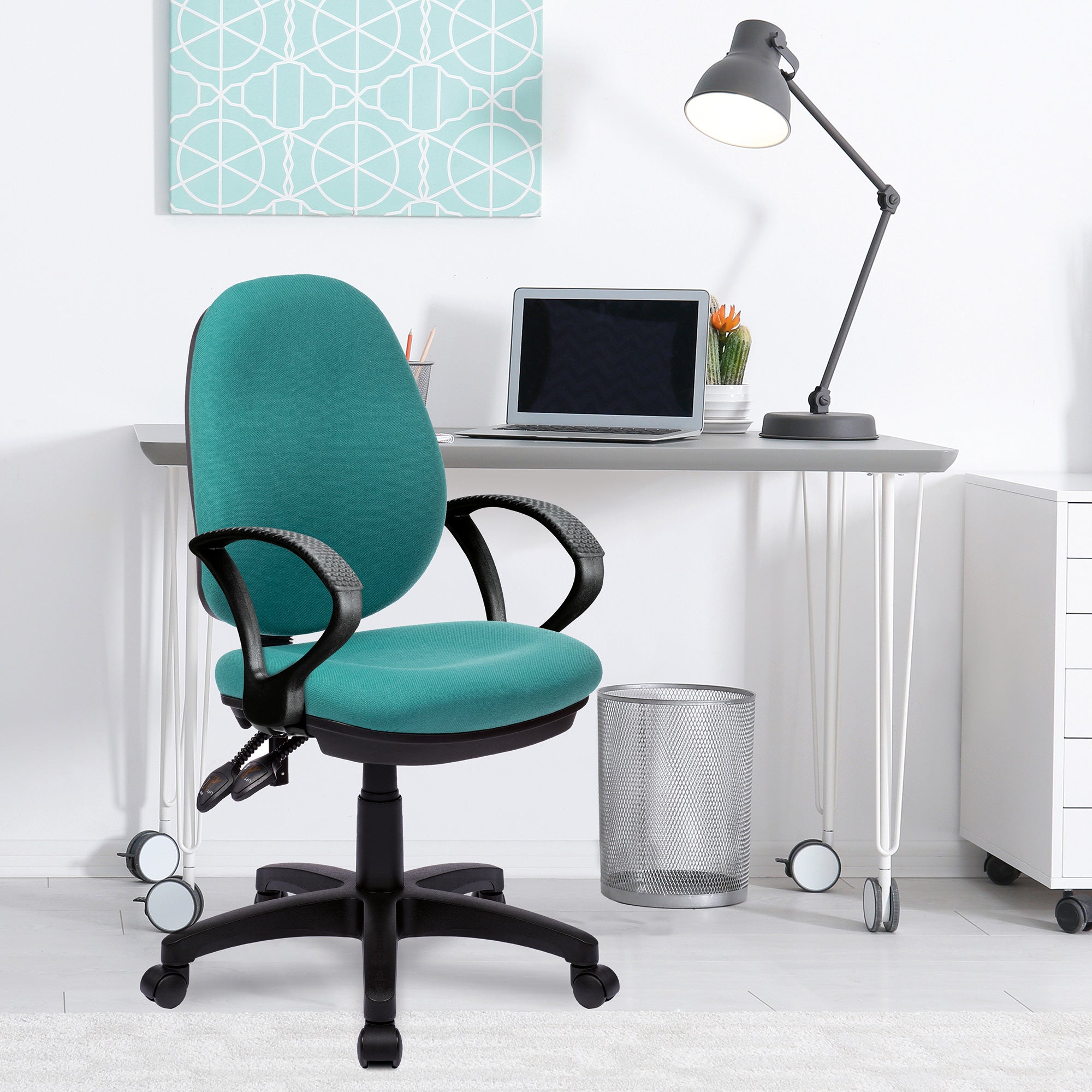 Teal office chair in a modern office setting with a desk and lamp.