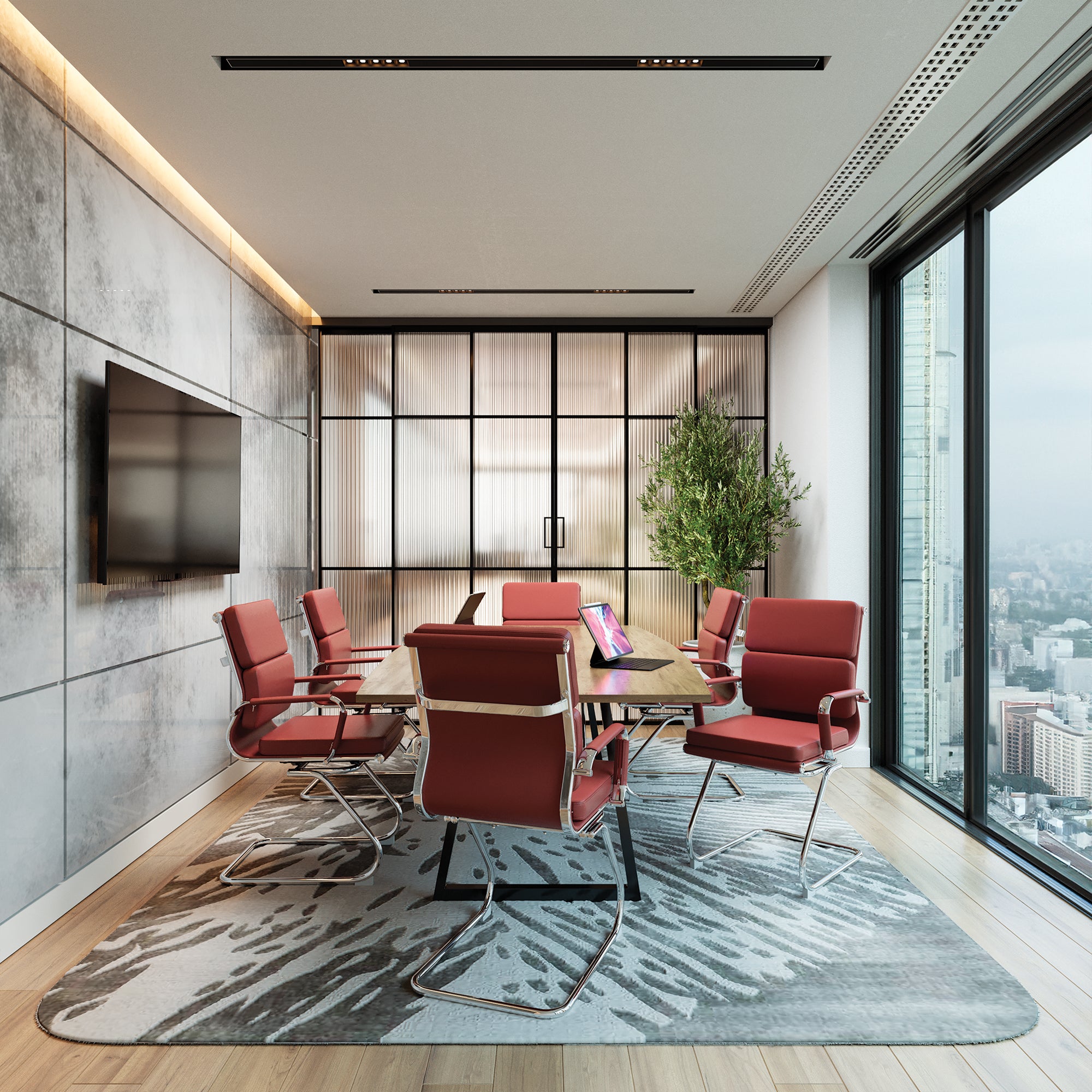 Modern conference room with red chairs, a table, and large windows overlooking a cityscape.