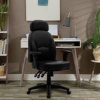 Black office chair in front of a desk with a lamp and books in a home office setting.