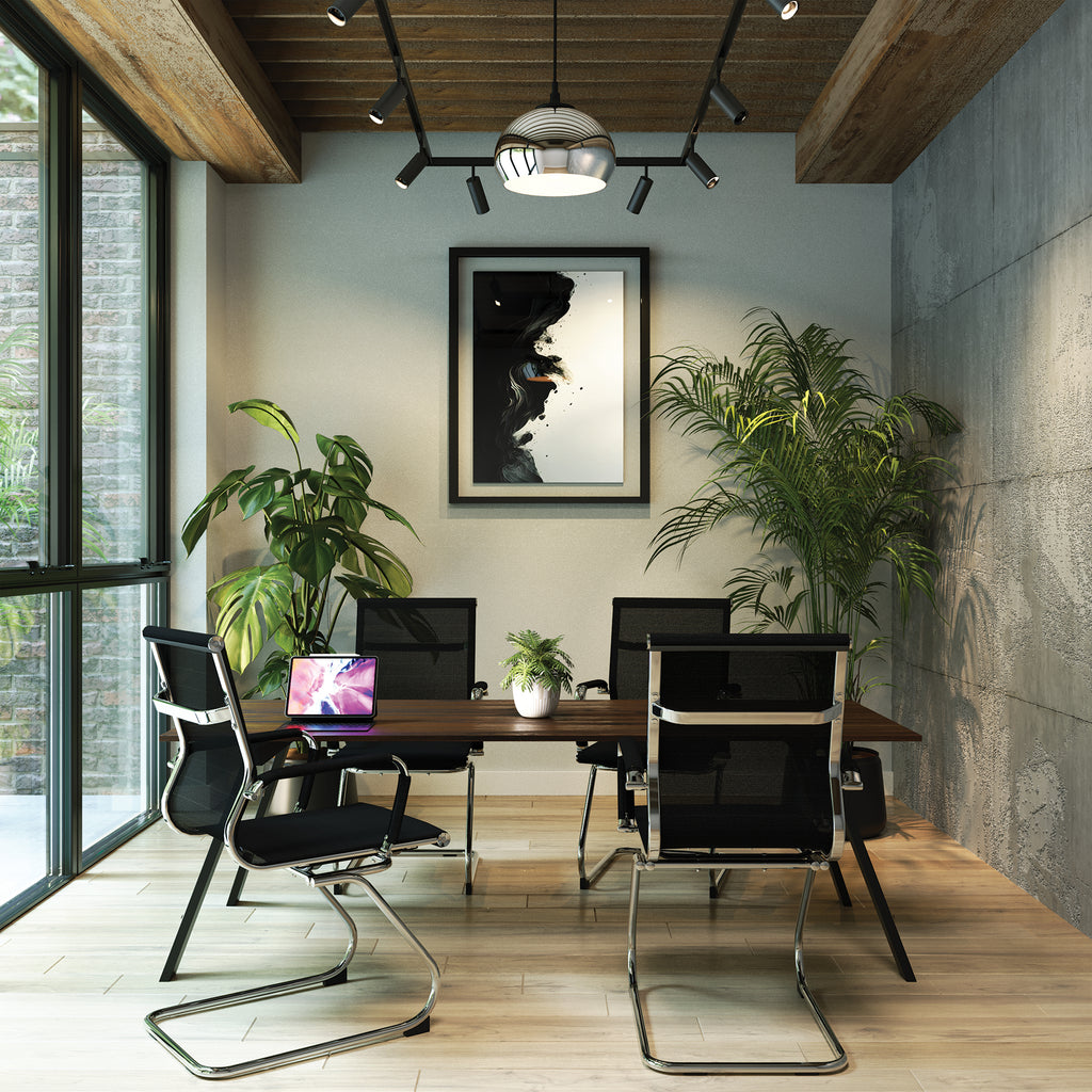 Modern office space with black chairs, a wooden desk, and plants.