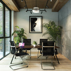 Modern office space with black chairs, a wooden desk, and plants.
