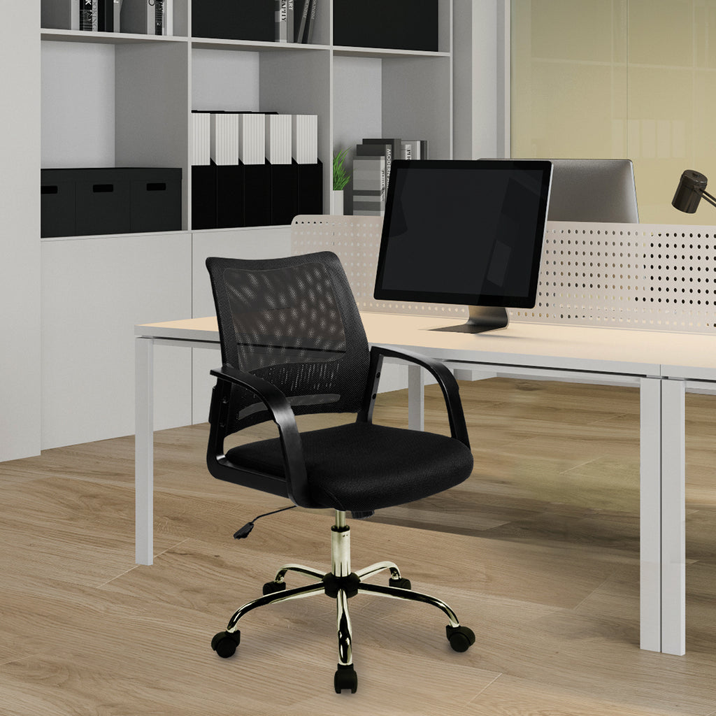 Black office chair in front of a white desk with a computer monitor in an office setting.