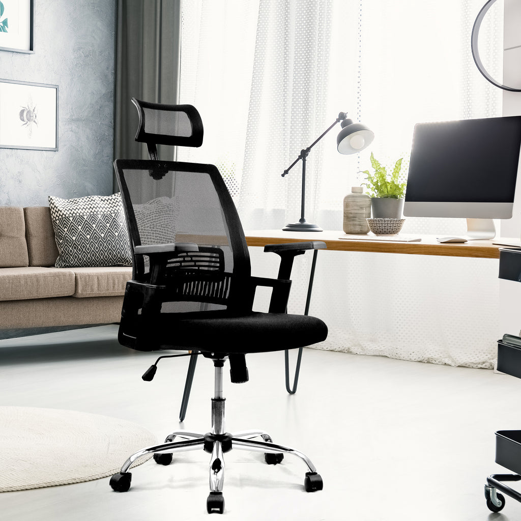Black office chair in a modern living room setting with a desk and computer monitor.