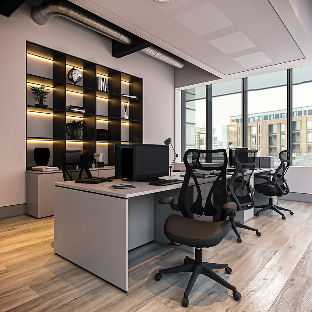 Modern office space with desks, chairs, and a wall with shelves.