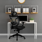 Modern office setup with a black ergonomic chair, white desk, computer monitor, and speakers against a grey wall.