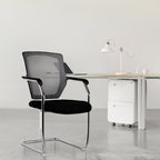 Black office chair in a minimalistic office setting with a desk and lamp.