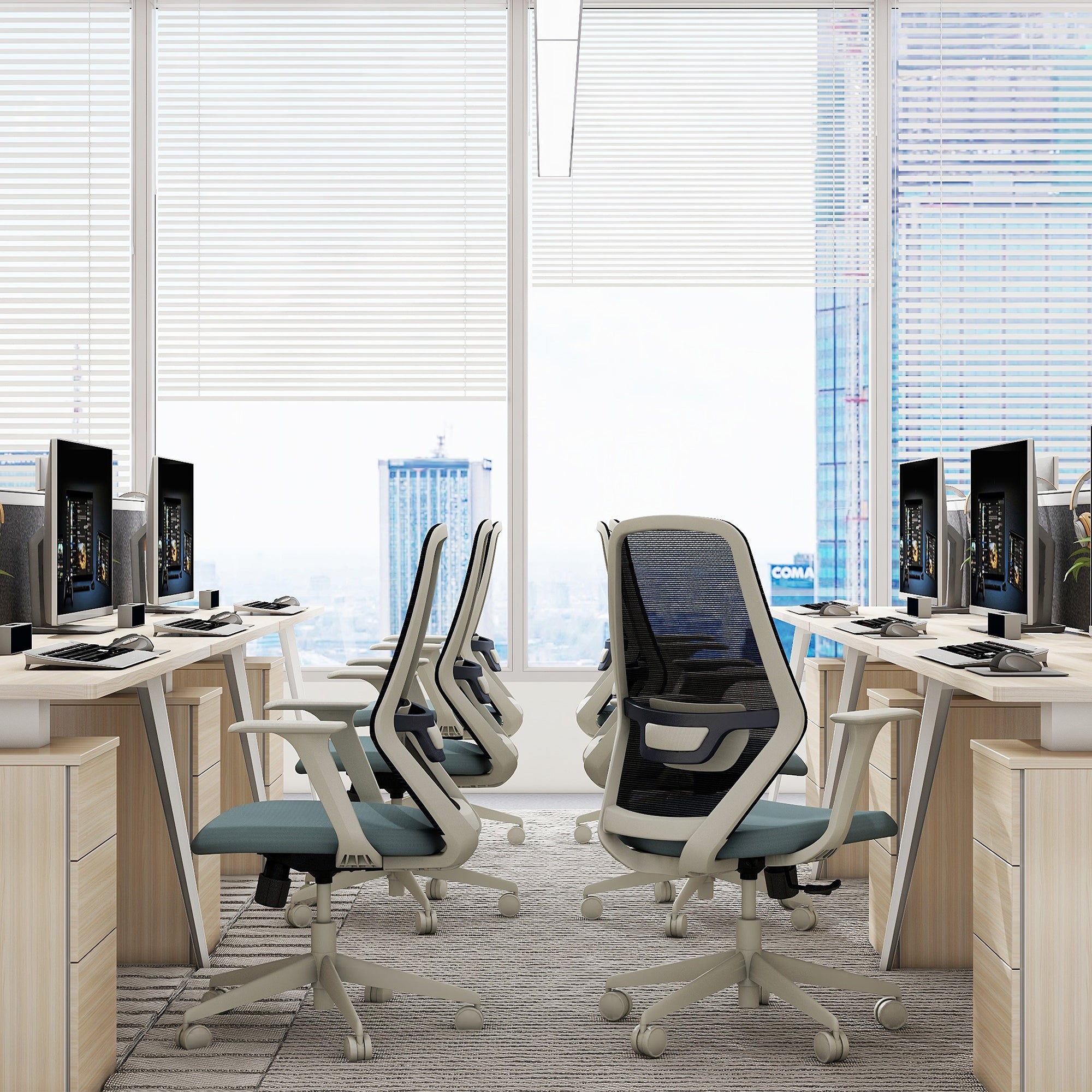 Modern office setup with ergonomic chairs and computer monitors in a bright room.