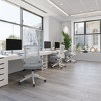 Modern office with white desks, chairs, and computer monitors.
