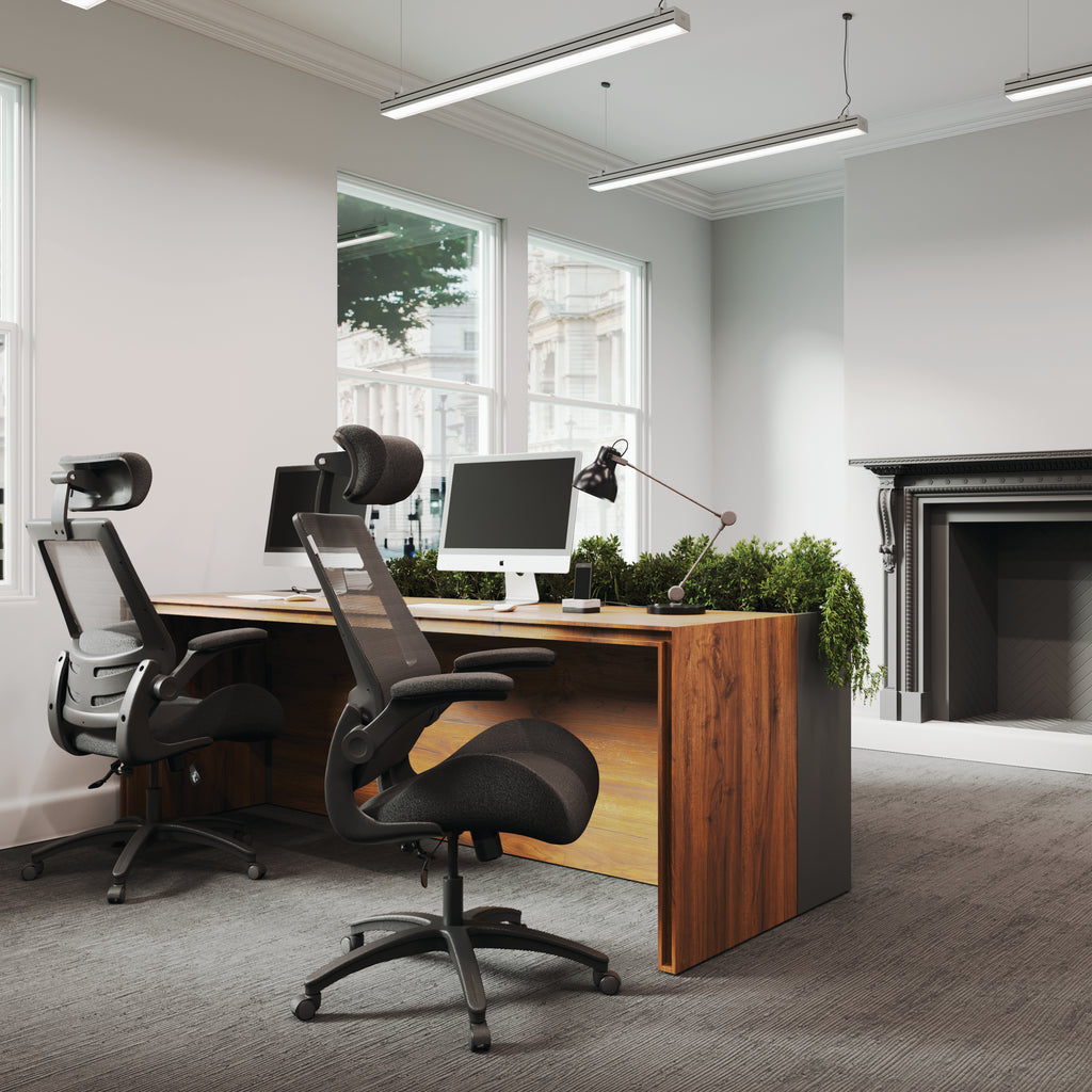 Modern office setup with a wooden desk, computer monitors, and ergonomic chairs.