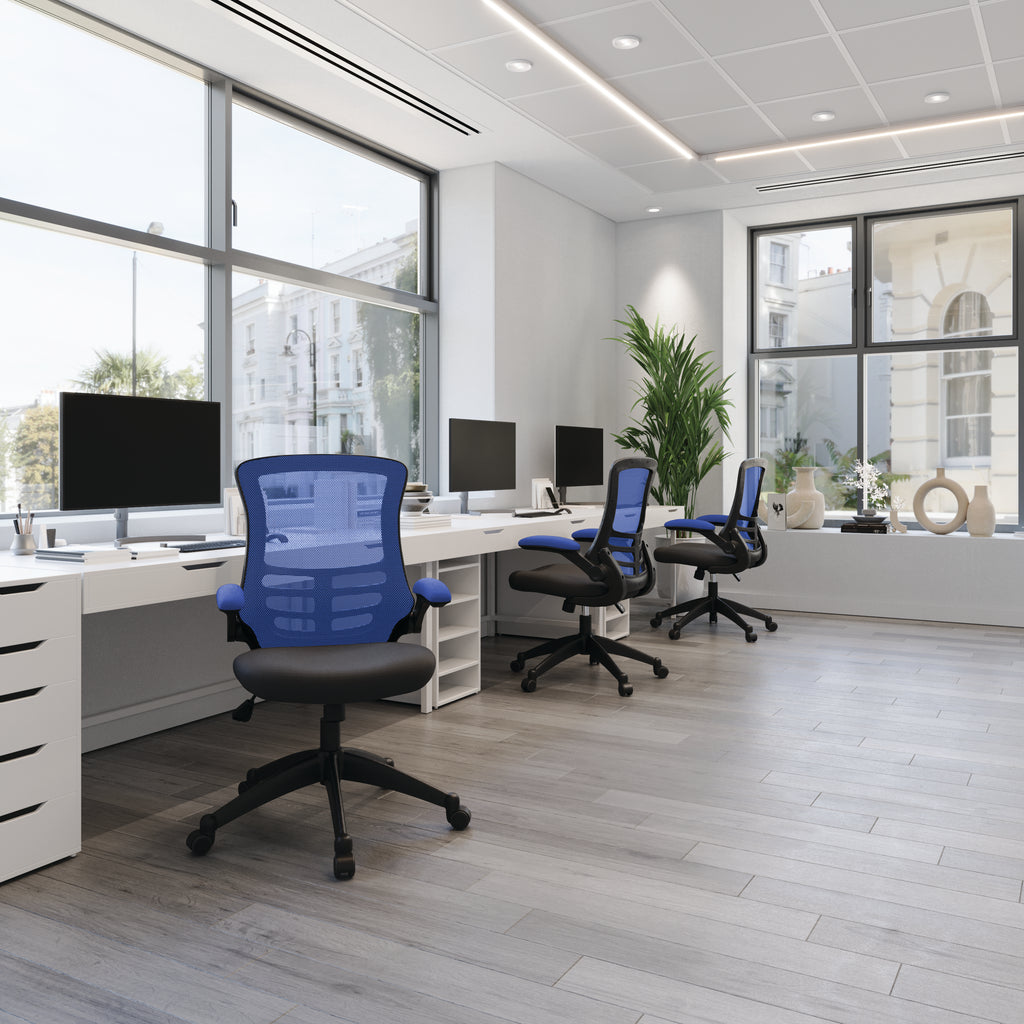 Modern office with desks, chairs, and large windows.