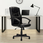 Black office chair in front of a desk with a laptop and lamp.
