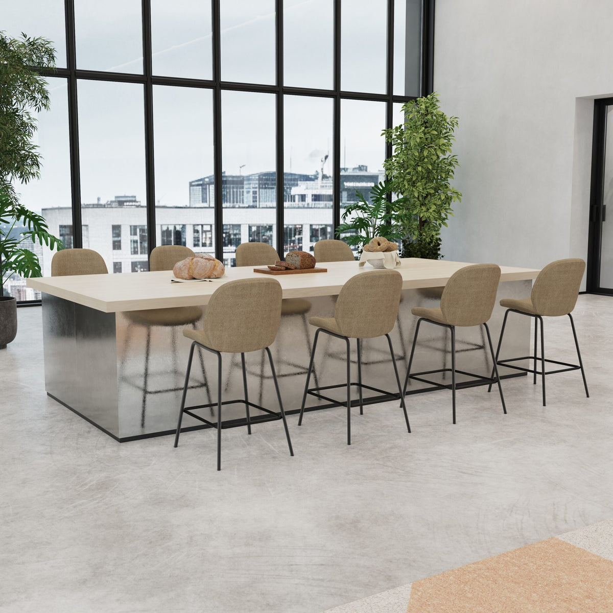 A modern rectangular bar-height dining table with a light wood top and reflective metallic base, surrounded by eight upholstered bar stools with beige fabric and black metal legs, set in a bright contemporary interior with large windows.