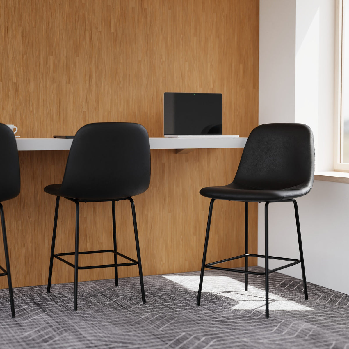 Black bar stools in a modern office setting with a wooden wall and desk.