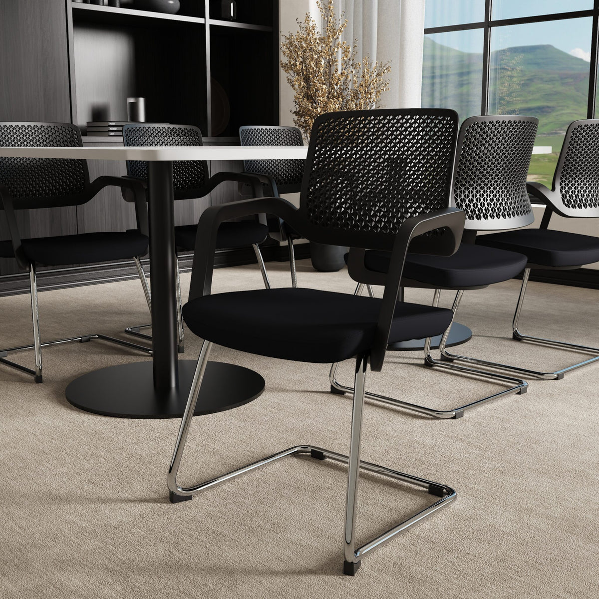Black office chairs next to a table in a meeting room setting with cupboards in the background