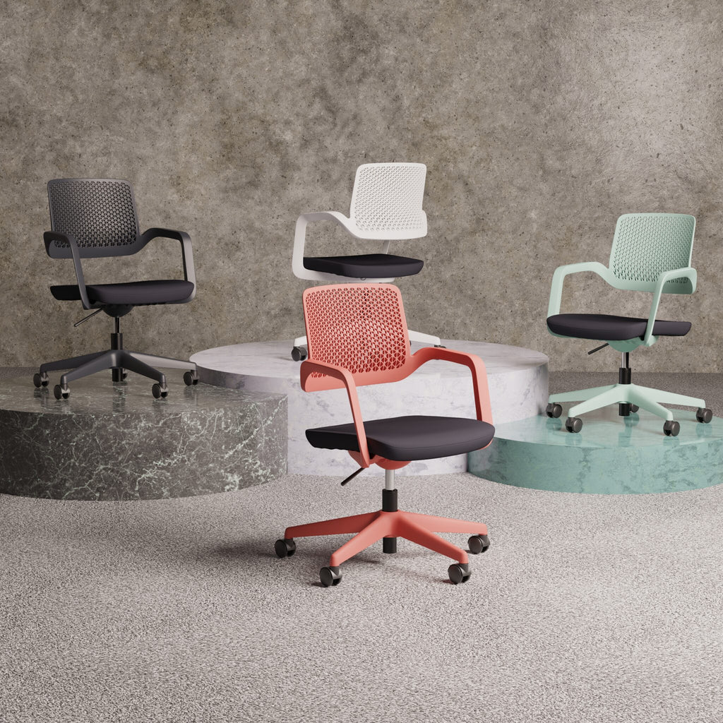 Four office chairs in different colours shown on a round pedestals with a grey wall in the background