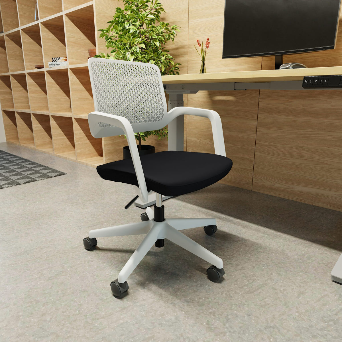 White office chair with black seat next to a desk with in a room setting with storage unit in the background