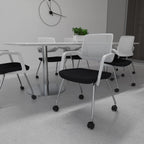 Black and white office chairs with metal legs next to a table with a clock and plants in the background