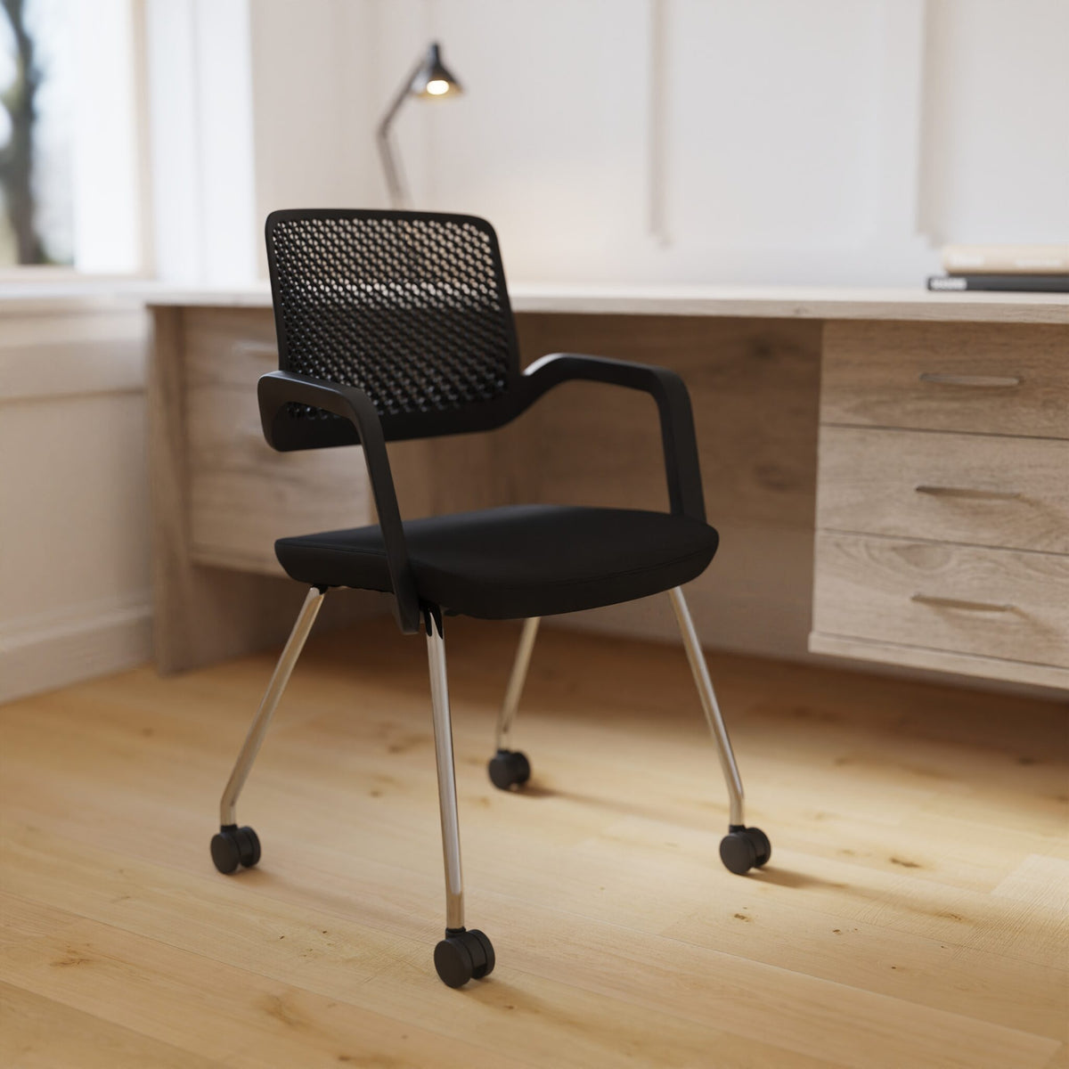 Black chair with metal legs next to a desk show in a room setting