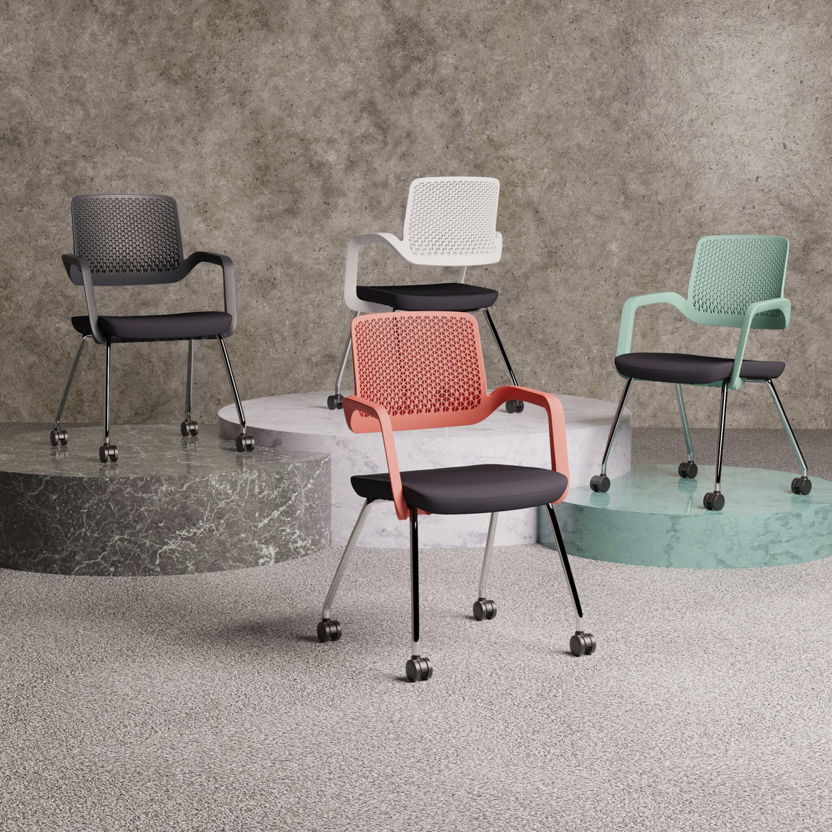Four office chairs in multiple colours shown on the pedestals with grey wall in the background 