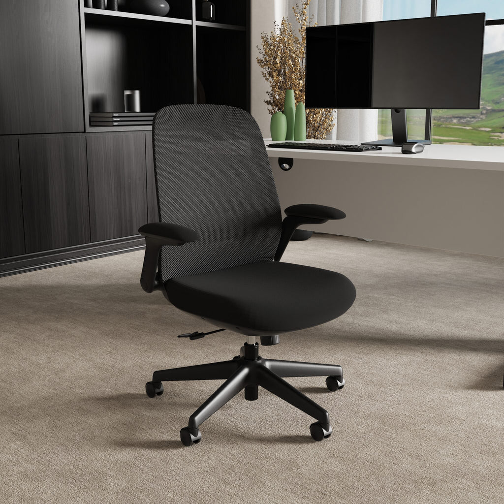 Black office chair in a room setting with a furniture in the background