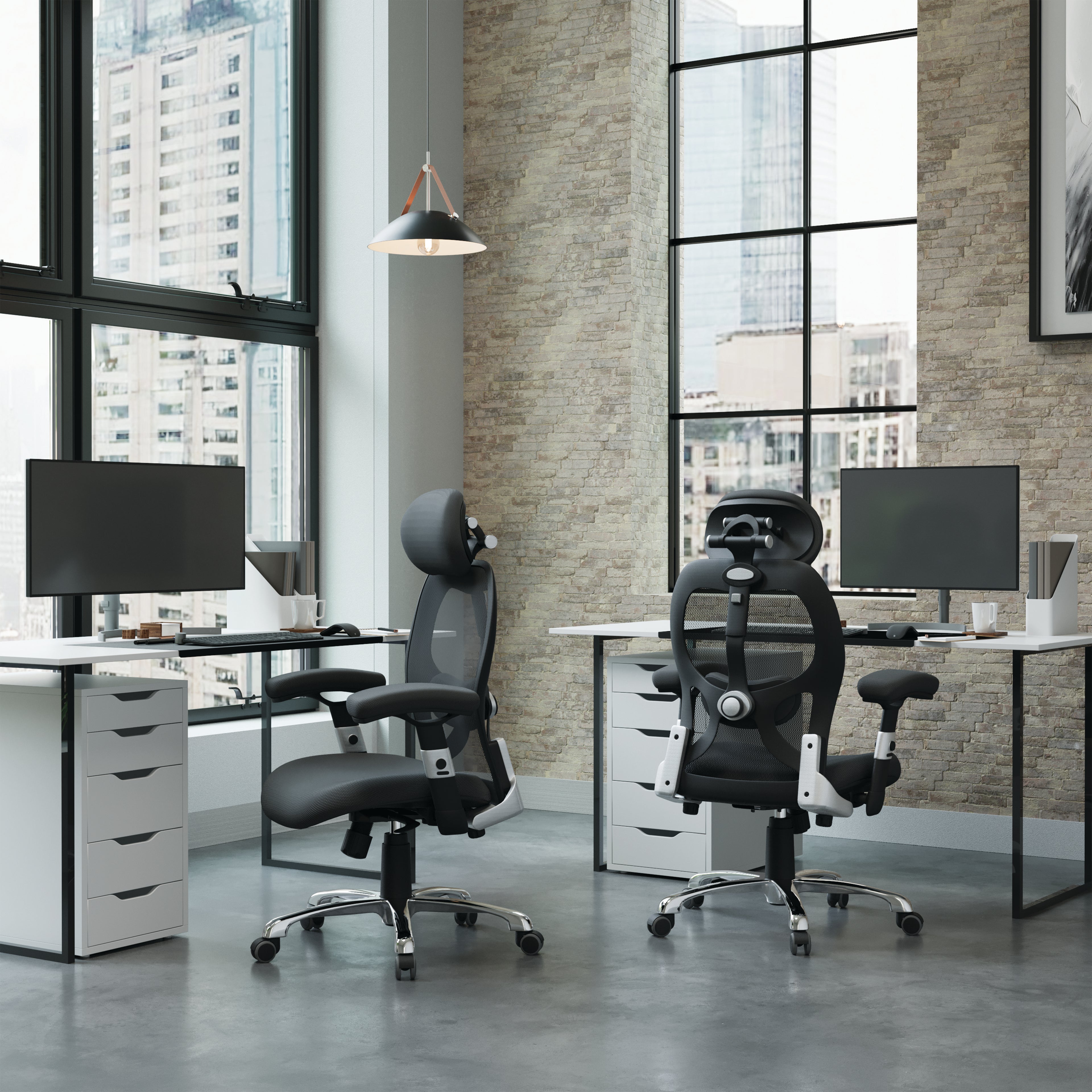 Modern office setup with two ergonomic chairs and desks in a large windowed room.