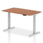 Adjustable height desk with wood-effect top and metal legs on a white background