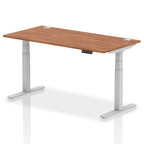 Adjustable height desk with wood-effect top and metal legs on a white background
