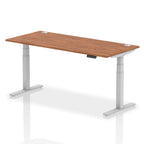 Adjustable height desk with wood-effect top and metal legs on a white background