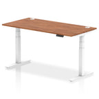Adjustable height desk with wood-effect top and metal legs on a white background