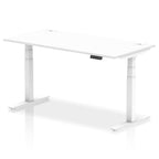 Adjustable height desk with white top and metal legs on a white background