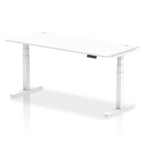 Adjustable height desk with white top and metal legs on a white background