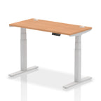 Adjustable height desk with wood-effect top and metal legs on a white background