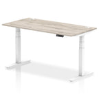 Adjustable height desk with wood-effect top and metal legs on a white background
