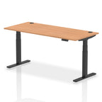 Adjustable height desk with wood-effect top and metal legs on a white background