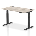 Adjustable height desk with wood-effect top and metal legs on a white background